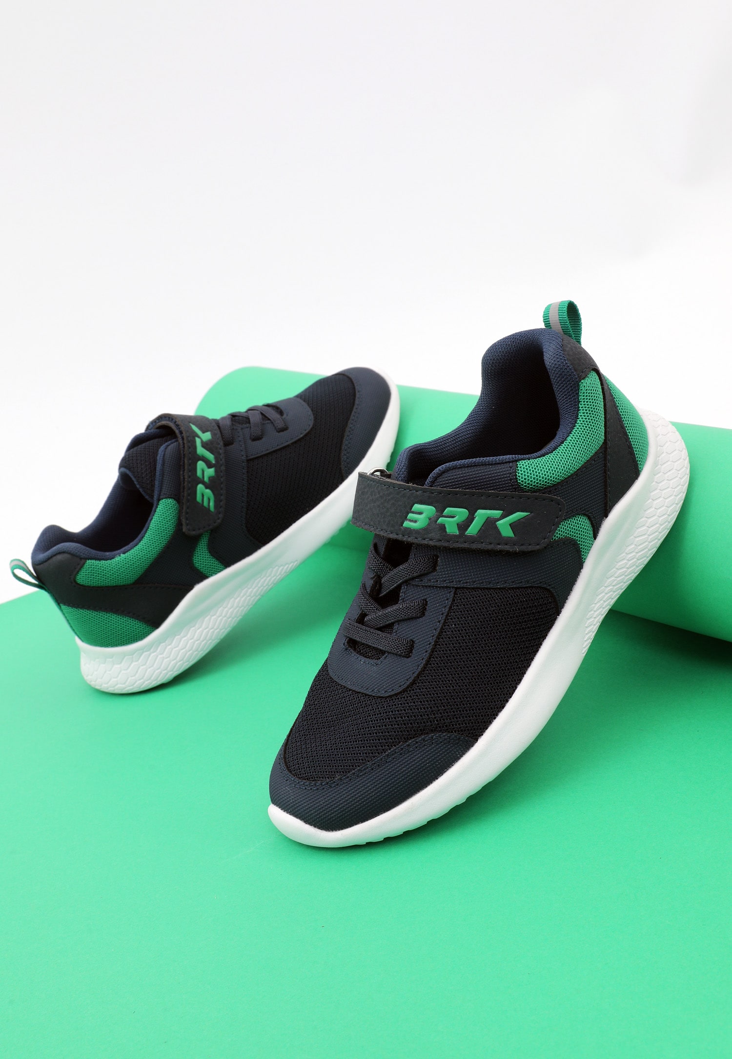 Czarno-zielone sneakersy na zielonym tle